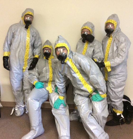 five people in full hazardous materials suits