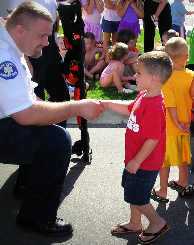 paramedic shaking a small Childs hand
