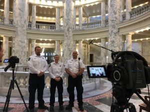 three paramedics standing in the capital with large marble columns surrounding them