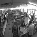 security camera footage of two people standing at a register