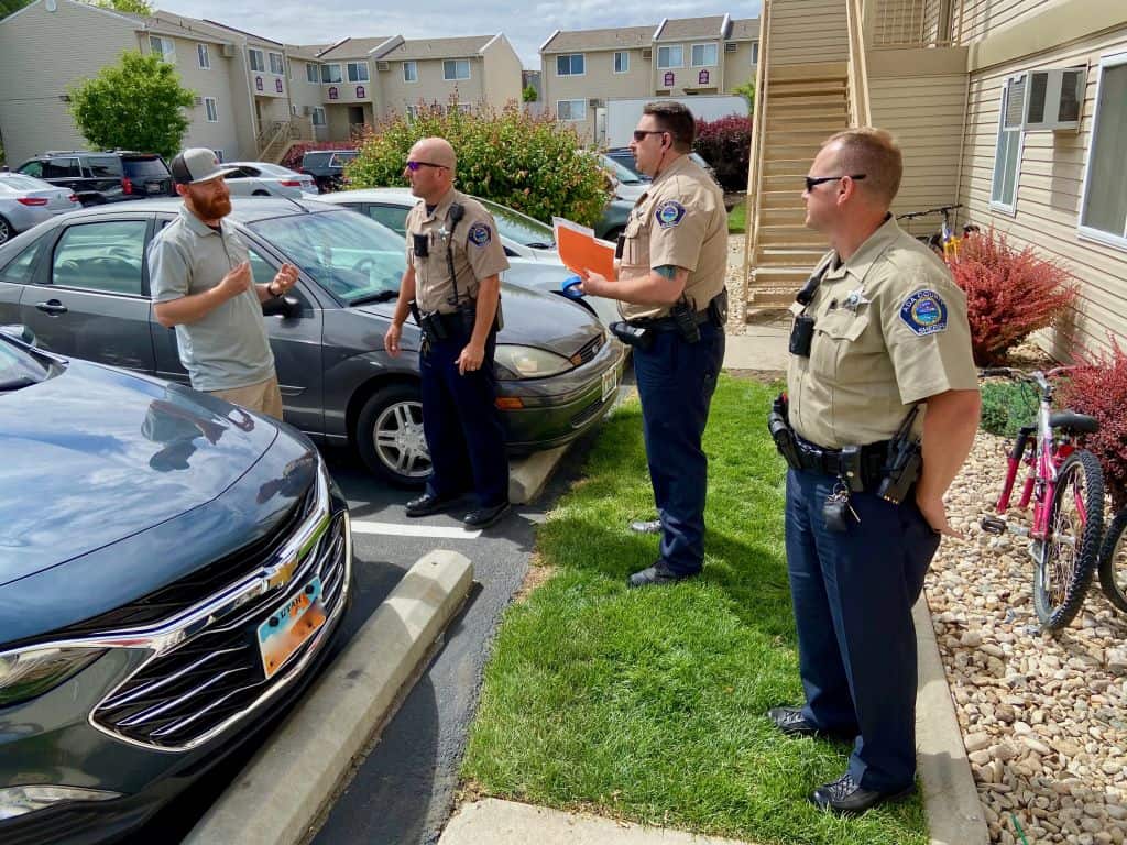 Three Sheriff's talking with a Citizen in a parking lot